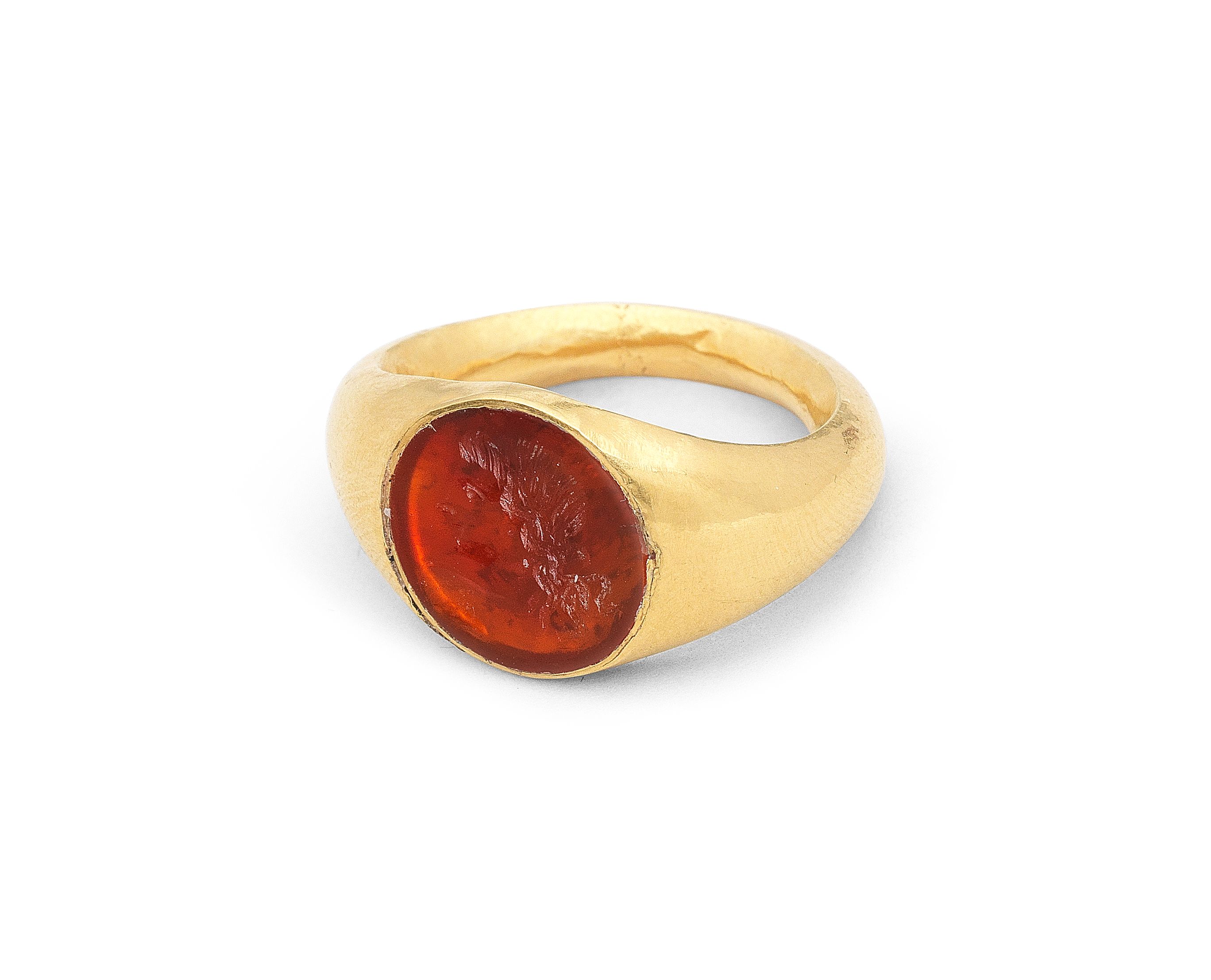 Bonhams A Roman gold and carnelian intaglio ring with a head of