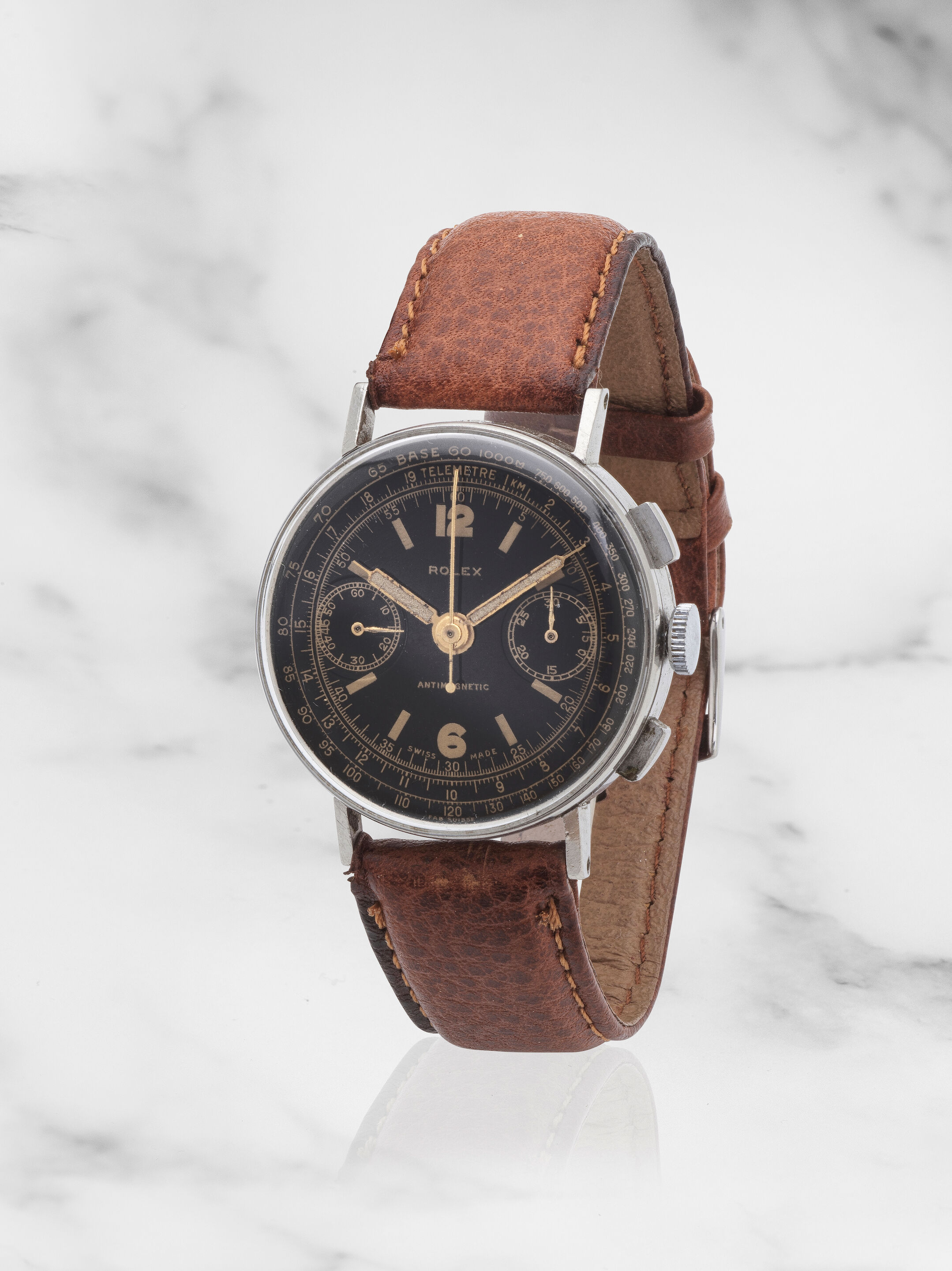 Steel 3484 of circa 1940 with a black varnished dial, gilt Arabic numerals and gilt tachymeter and telemeter scales; registers at three and nine. · Photo: Bonhams · © Bonhams, used with permission · Source: https://www.bonhams.com/auction/29739/lot/14/rolex-a-fine-stainless-steel-manual-wind-chronograph-wristwatch-rolex-beau-chronographe-bracelet-en-acier-mouvement-mecanique-antimagnetic-ref-3484-circa-1940/